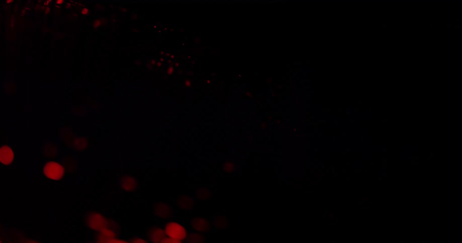 Glowing round red lights move in the darkness