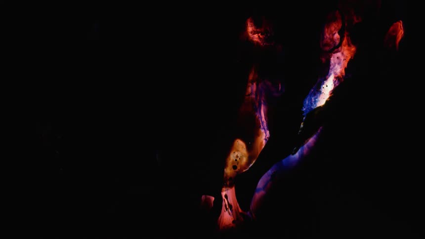 An area of glowing colors is covered by the darkness