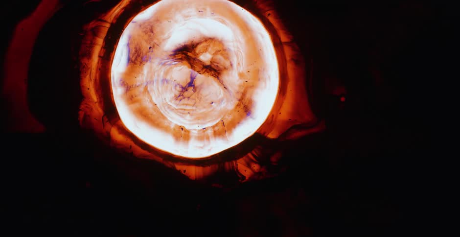 Illuminated liquid flows quickly into a dark space and appears almost like an explosion