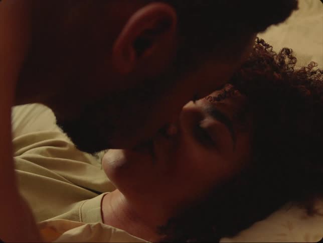 A couple kiss in bed