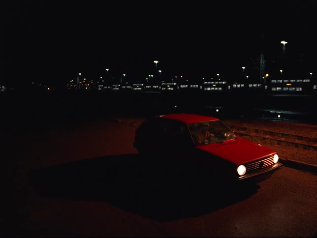 A parked car is in a parking lot during the night time