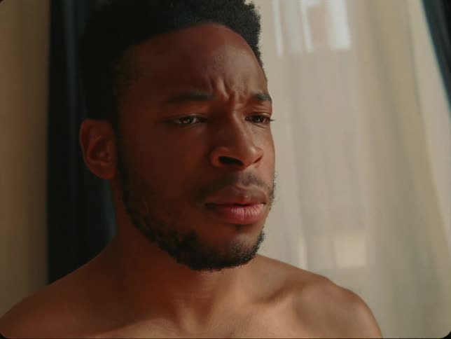 Man stops smiling then frowns in thought