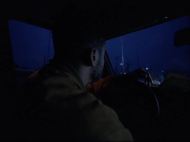A black male sitting in a vehicle looking around