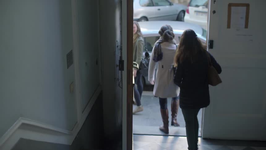 Three women leave a building