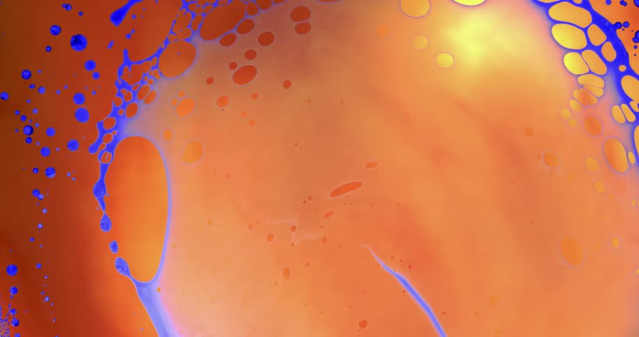 A ring of purple colors grows in an orange environment spreading with dots and then shrinking back down