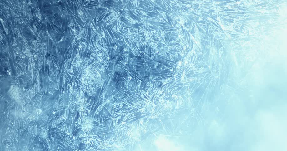 Light shines upon a cracked and textured icy surface as bubbles move below