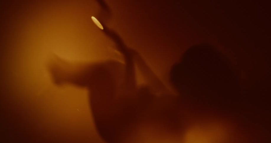 Silhouette of baby with umbilical floats surrounded by amber light