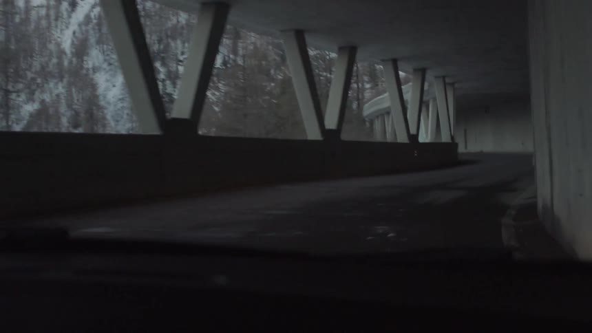 Driving through a mountain tunnel that is open to a view on one side
