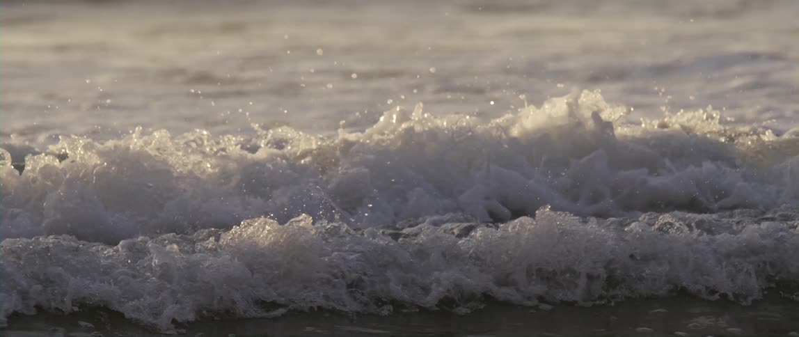 Ocean waves splash and foam as they roll into shore