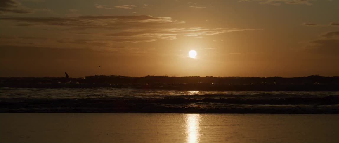 The view is of the ocean and beach in the middle of the day