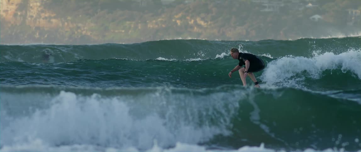 Surfer surfing over treacherous waves in the ocean
