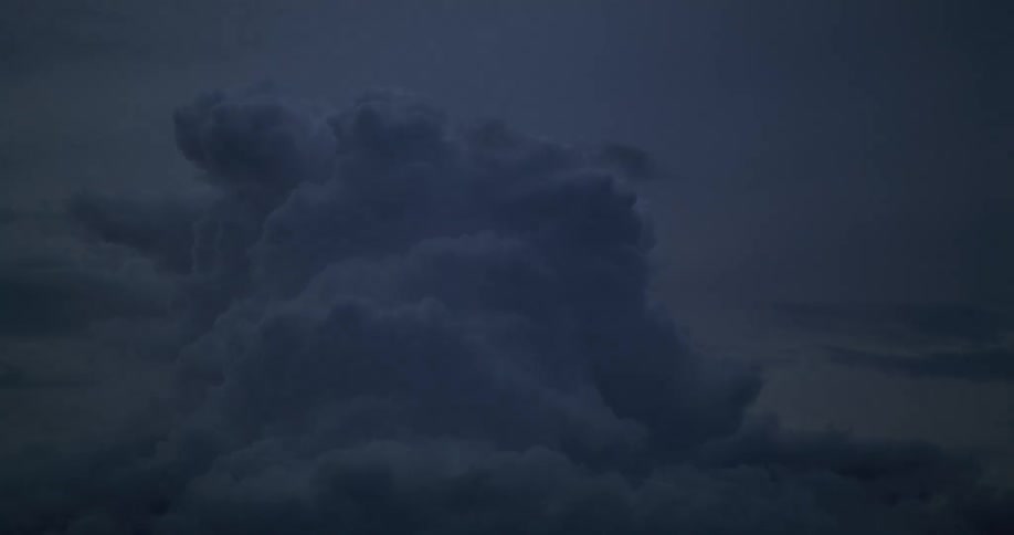 Cumulus clouds move across the sky as darkness falls