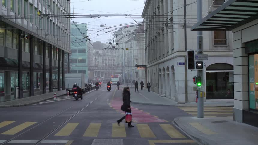 A woman crosses the street on a crosswalk