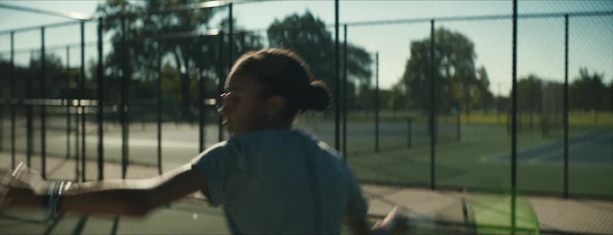 A girl is swinging a tennis racquet