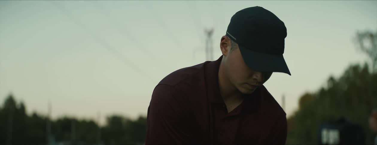 A man looks and concentrates then swings a golf club