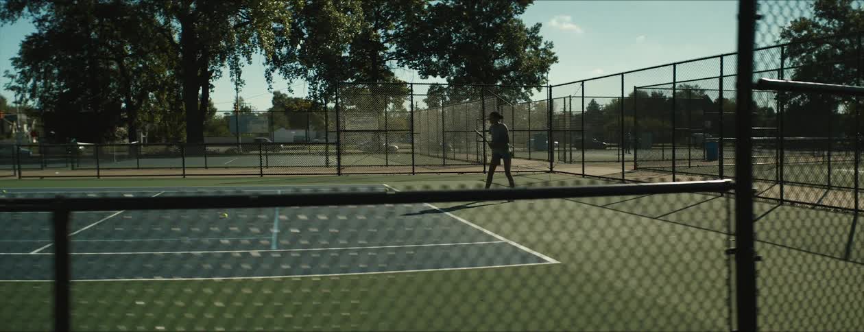 Woman plays tennis using a racket to hit ball at tennis court