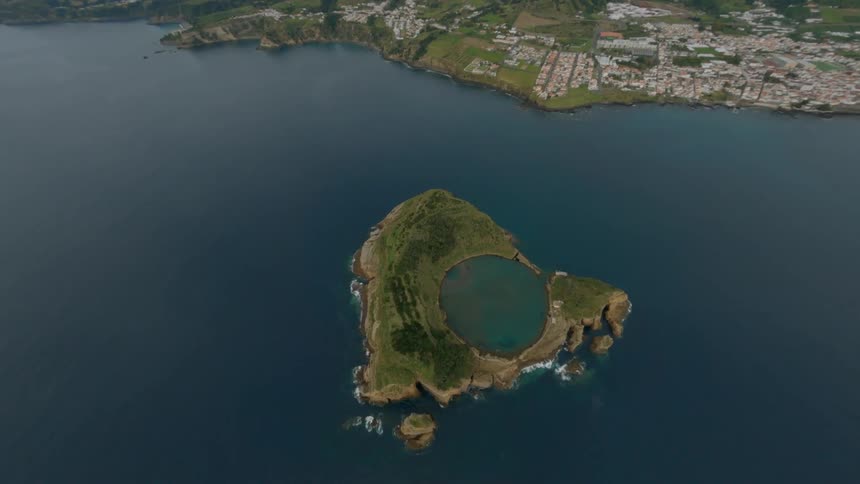 Blue water lines the shore of the island and town