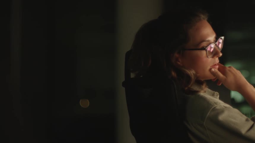 A young white woman is sitting down inside of her house
