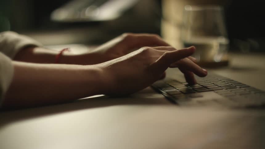 A person is typing on there computer in there room