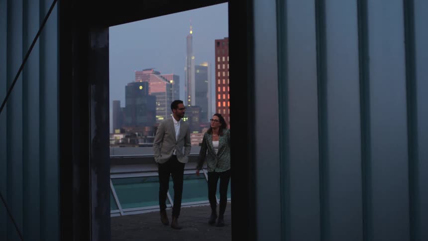 A man and woman walk on the roof top