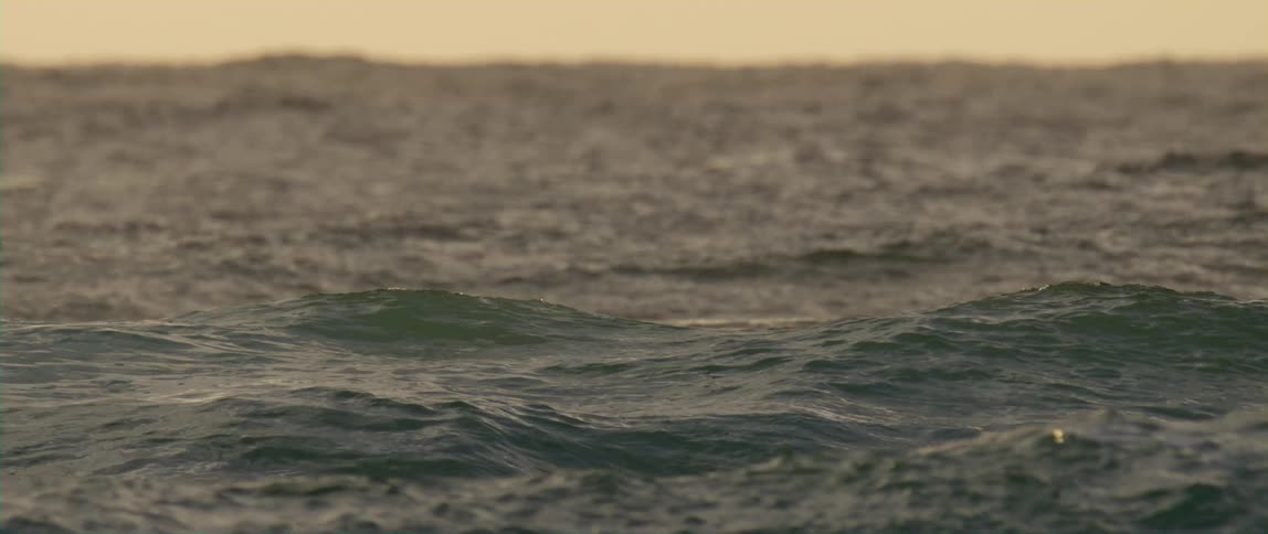 The view is of the ocean waves outdoors in the middle of the day