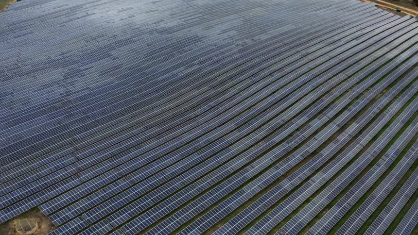 Aerial shot of endless rows of solar panels on a large solar farm during the day