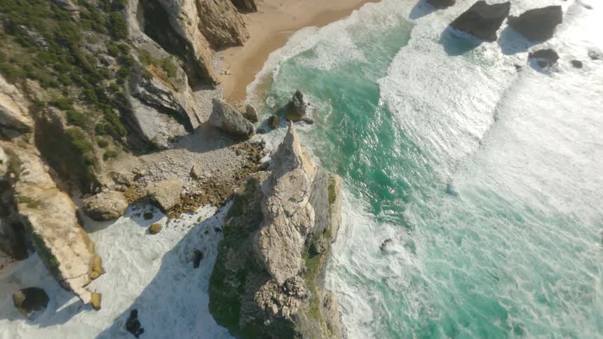 Dynamic aerial view of a rock promontory near a cliff on the coast at morning