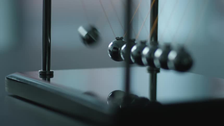 The balls of a newtons cradle swing back and forth
