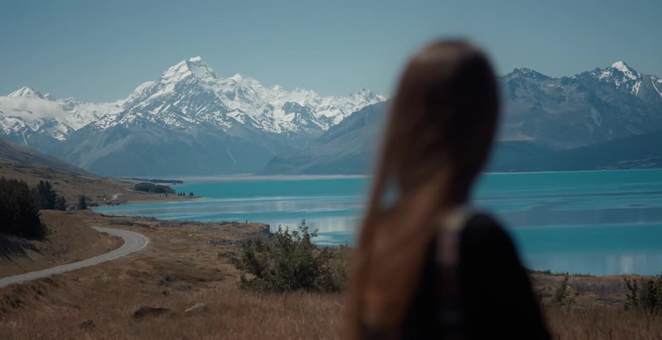 A brunette female standing outside looking at mountains