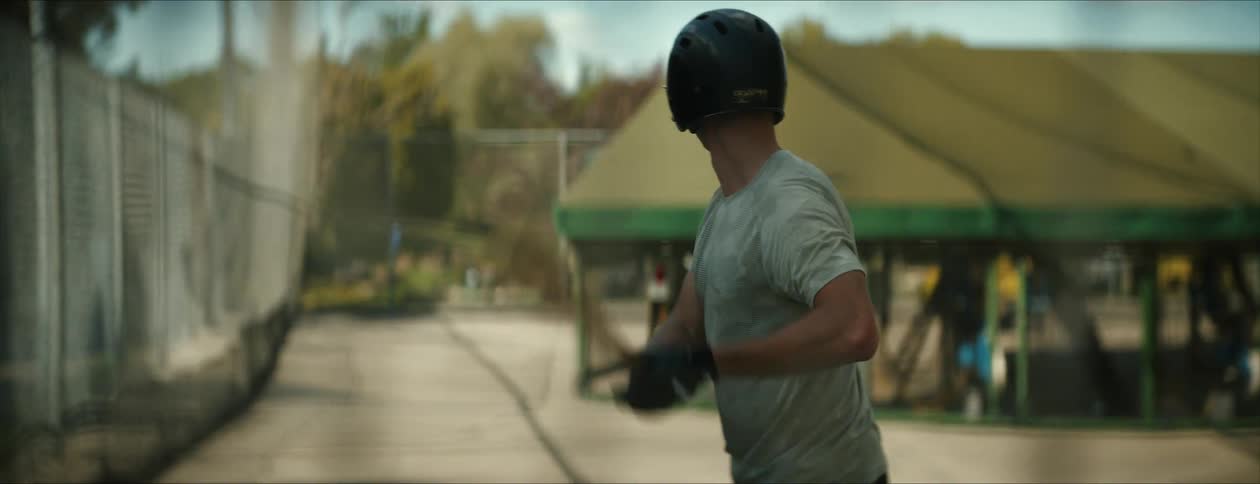Male hitting a baseball in outdoor batting cages