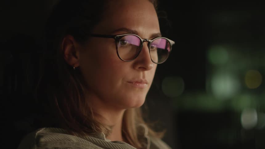 Woman wearing glasses working late at the office