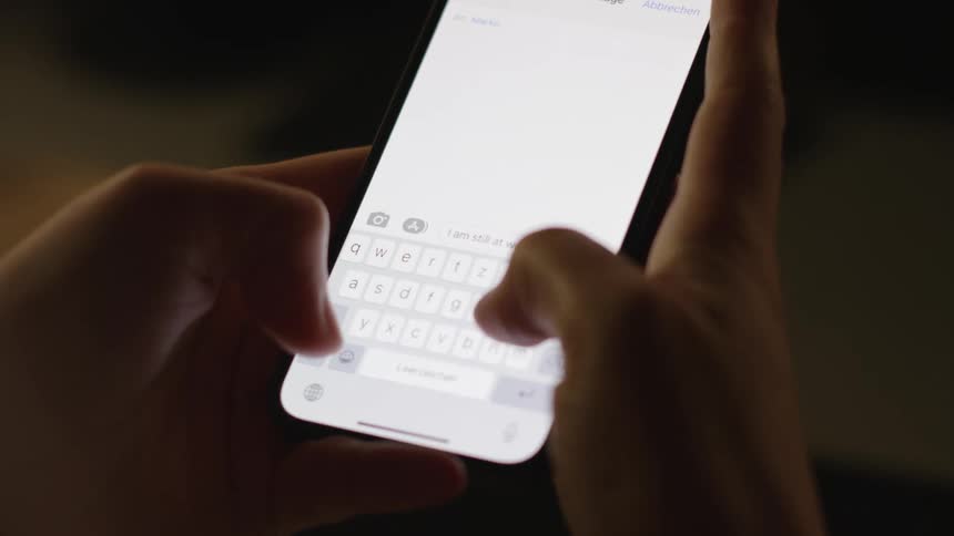 Someone is holding their phone with both hands and texting with their thumbs