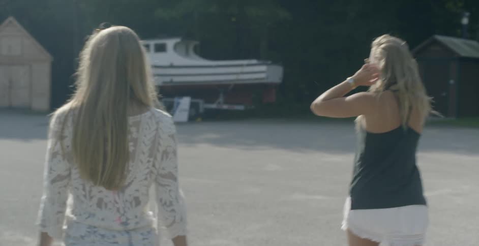 Women walk over to a boat in a lot