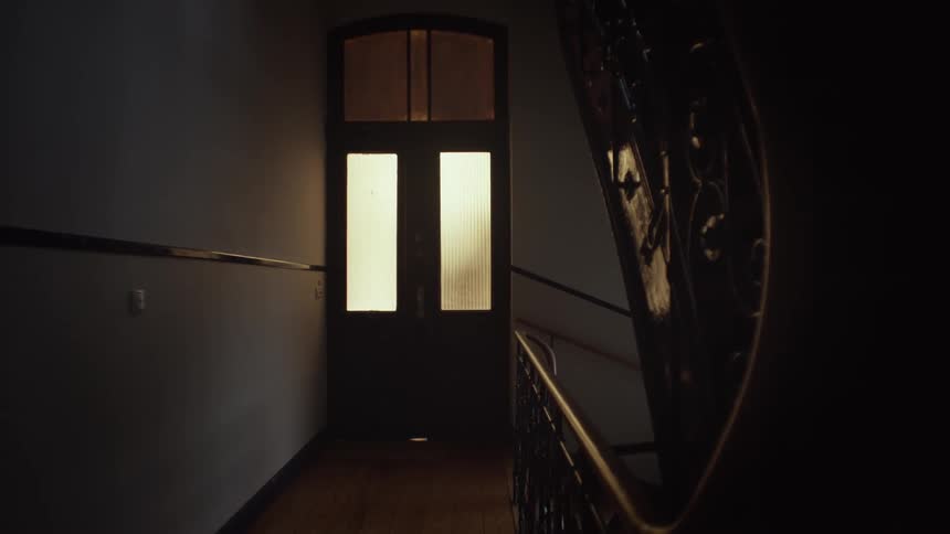 A light comes on and illuminates a dark hallway