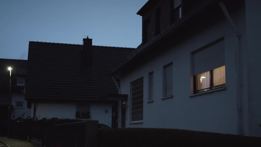 The shades go up automatically on the window of a house