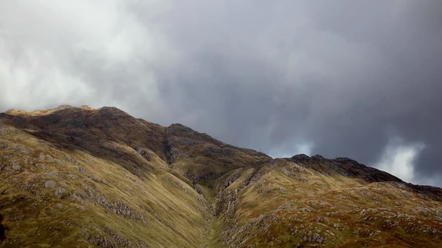 Time lapse of dark clouds moving over a hill