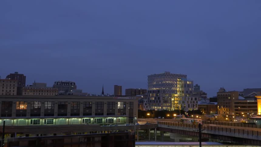 A bus travels down a road in a city at dawn