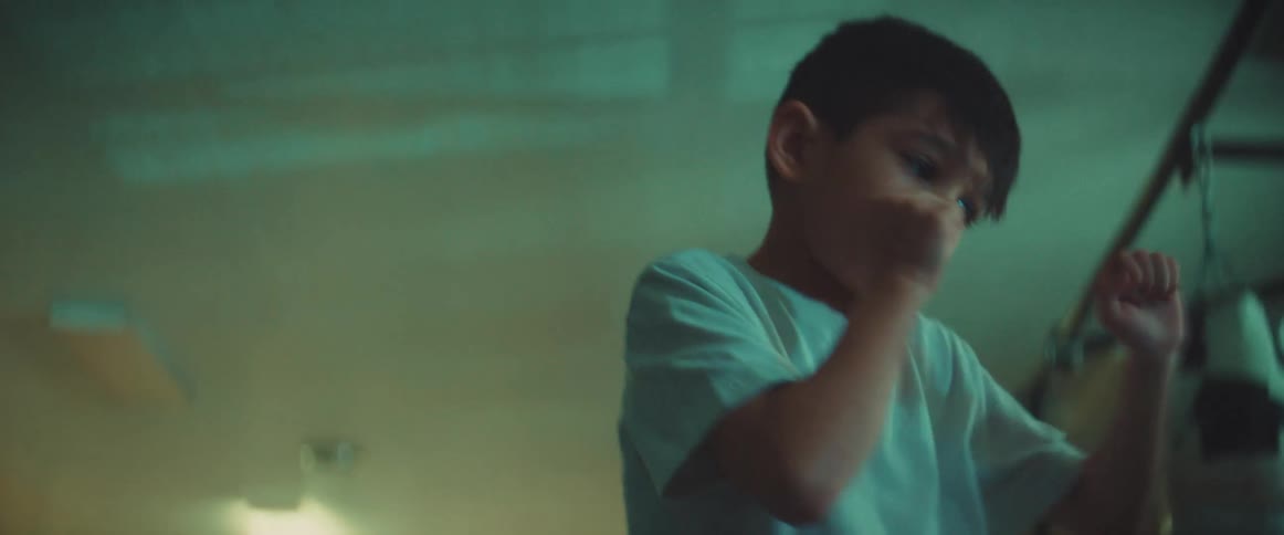 A boy shadow boxes in a boxing gym