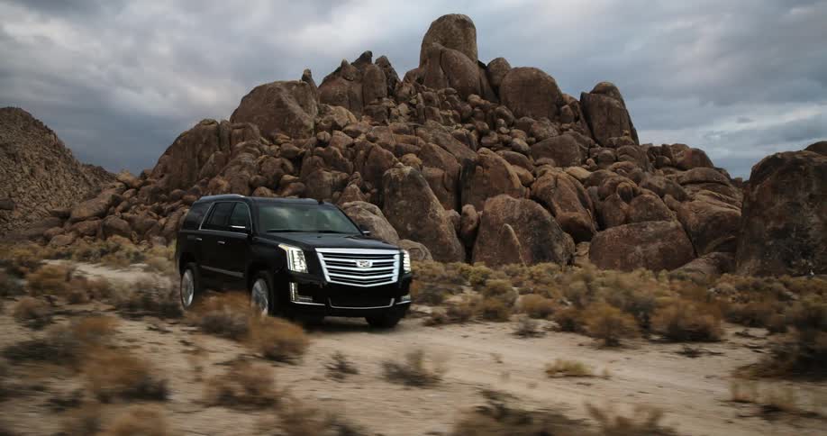 A black suv driving on a dirt trail through the canyon