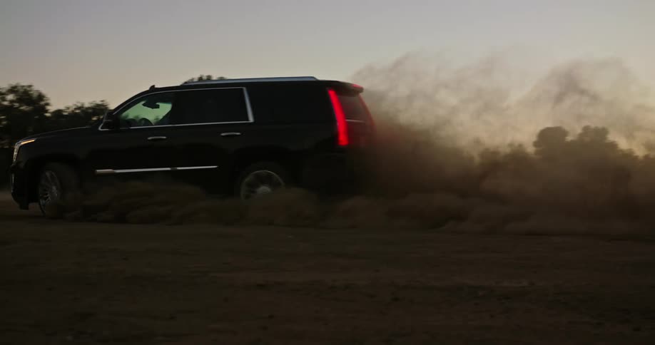 A person is spinning their vehicle out in a large dirt field