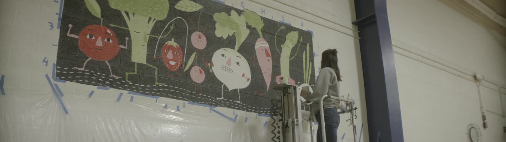 A woman works on a mural
