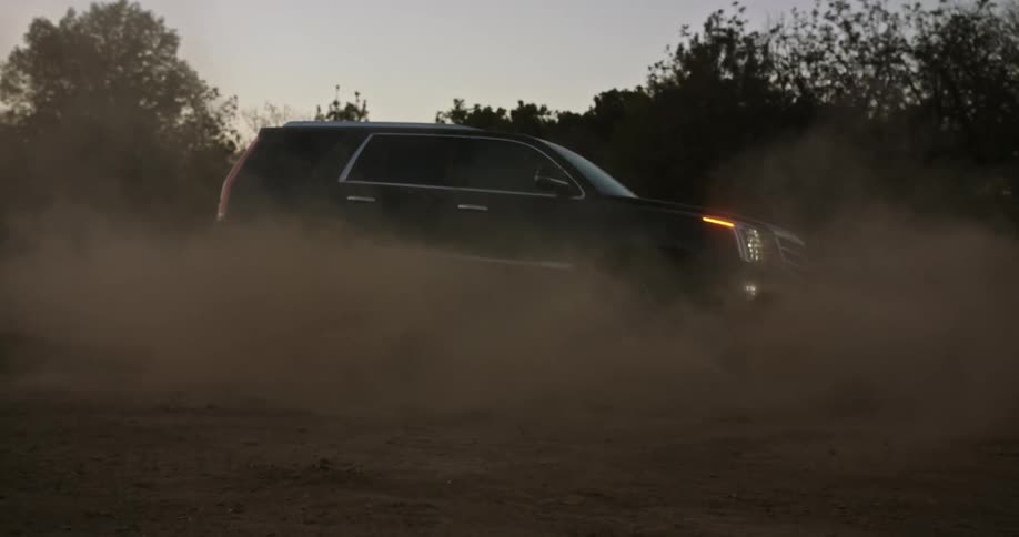 A car is driving on the dirt road in the middle of the wilderness