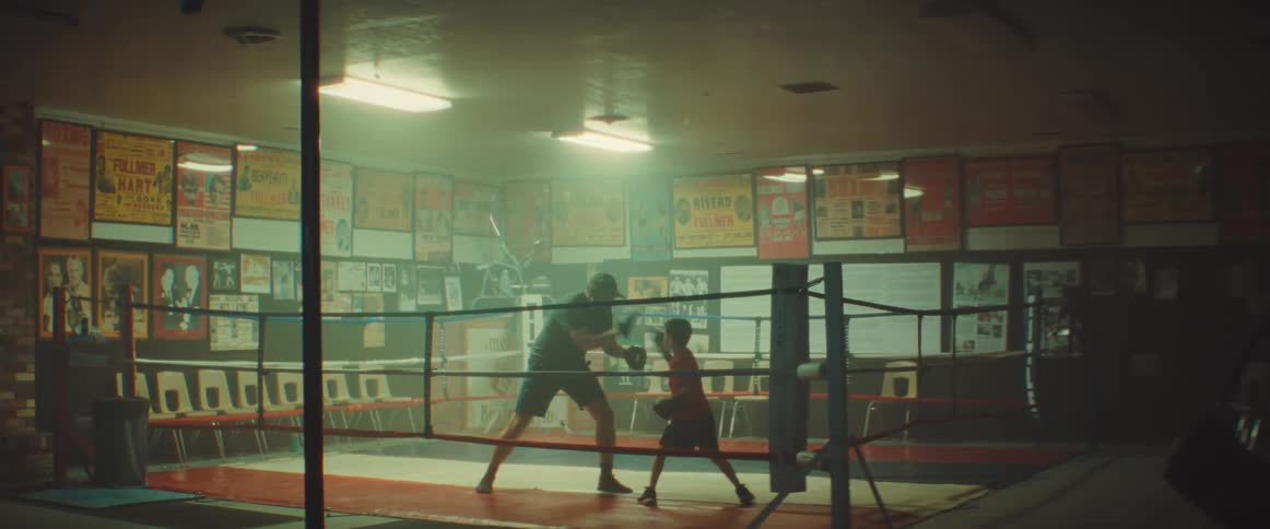 Father and son practicing box on a ring at the gym