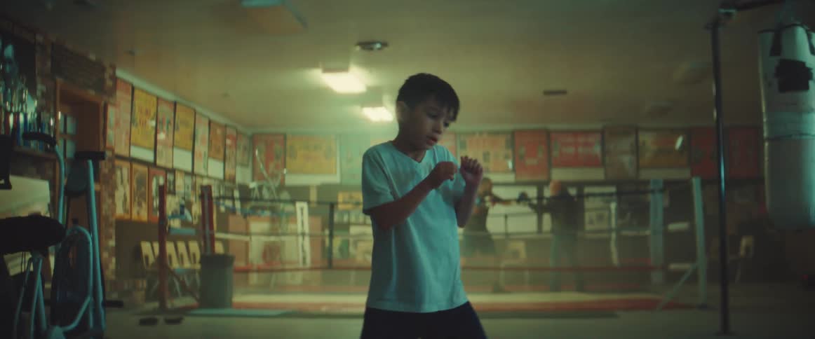A boy shadow boxes in a boxing gym