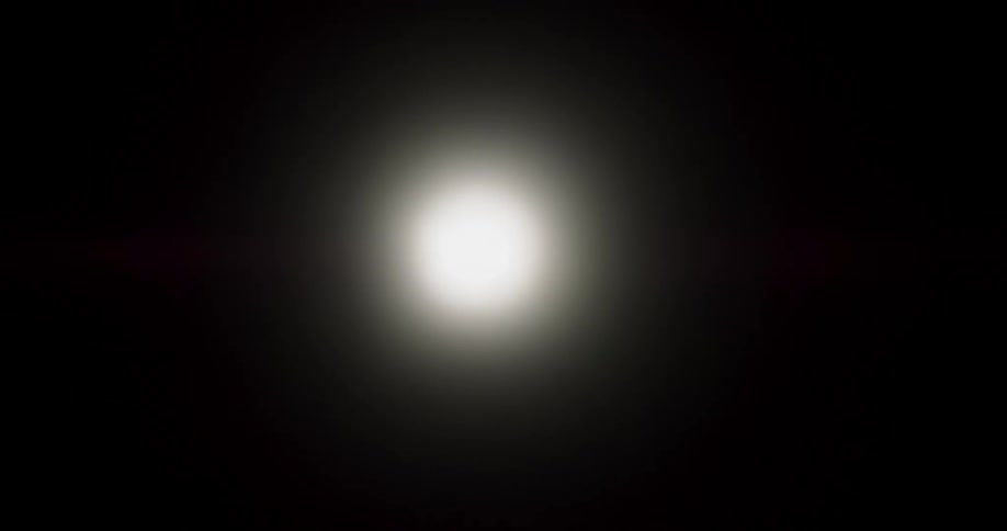 Bright white lights flicker while moving on the interior of a cylinder