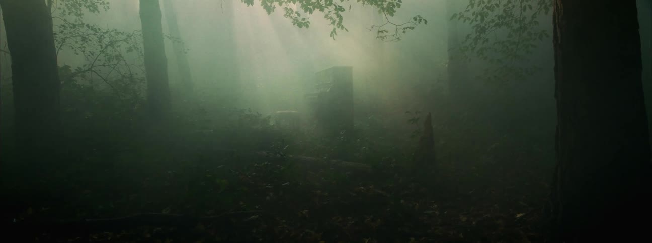 Abandoned piano on a clearing in the wood surrounded by mist under sunlight