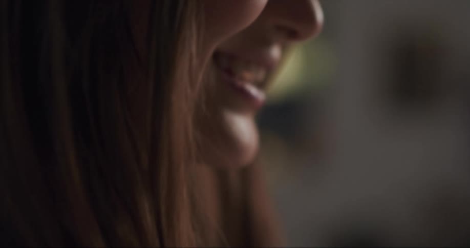 A woman uses a smartphone to participate in a video call with an older couple