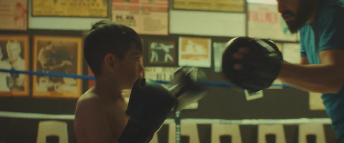 Male trainer trains boy in boxing in ring in boxing gym