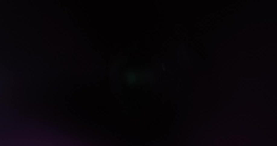 Bright magenta and purple lights flicker while moving on the interior of a cylinder