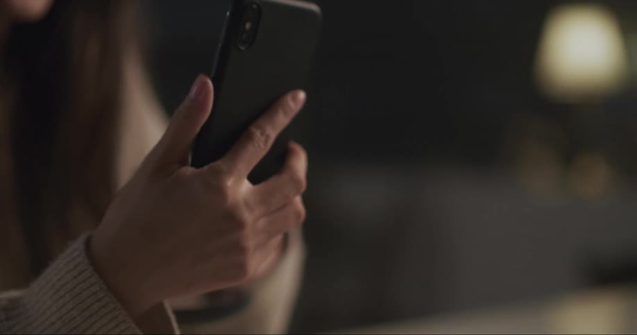 A woman is holding her cell phone in her hand